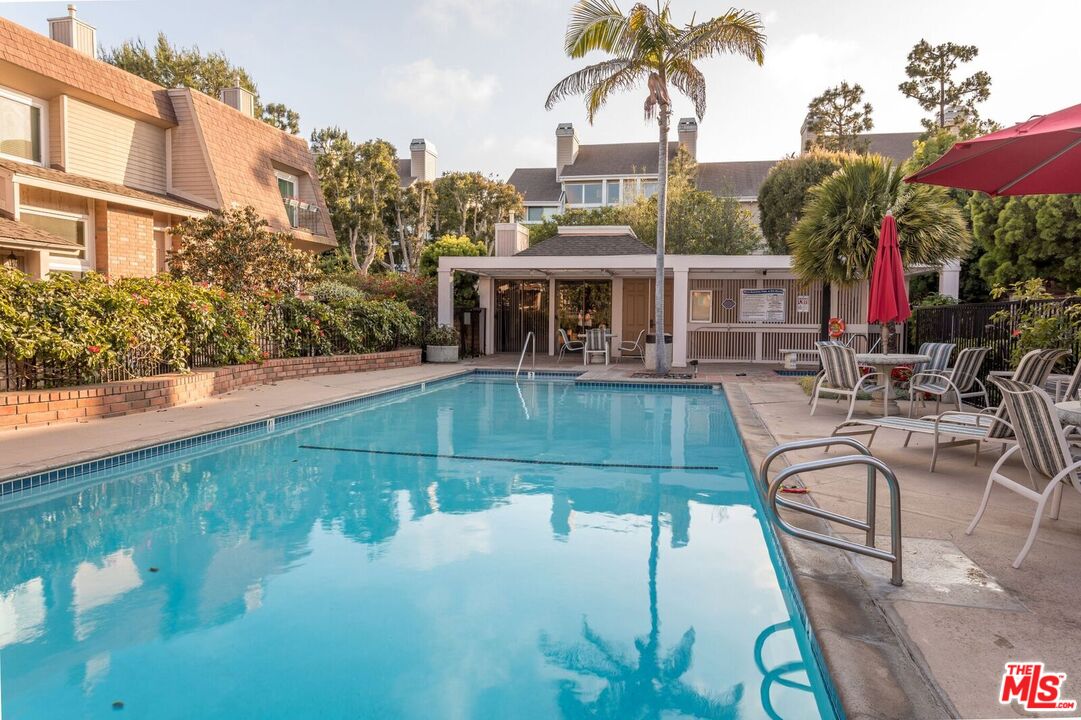 a view of a swimming pool with a patio and a yard