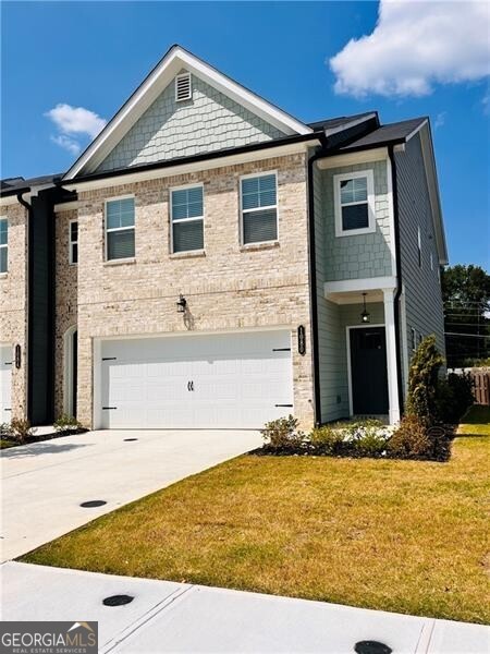 View of front of house featuring a garage and a front yard