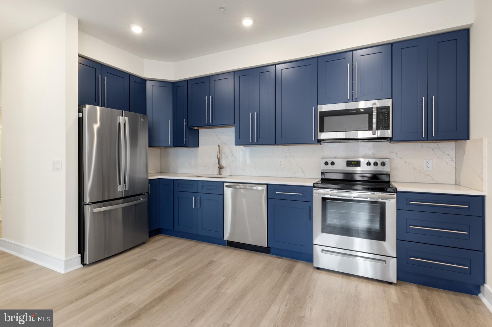 a kitchen with granite countertop wooden cabinets and stainless steel appliances