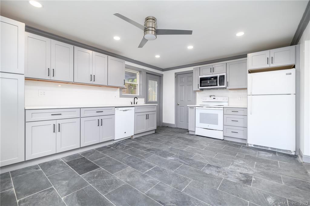 a kitchen with white cabinets and white appliances