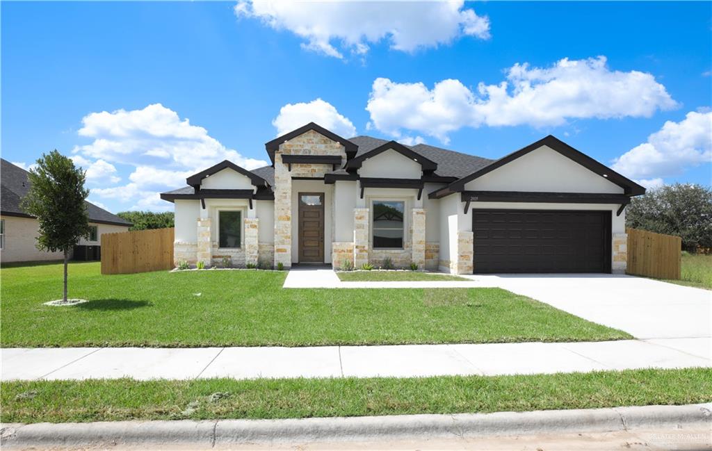 a front view of a house with a garden and yard