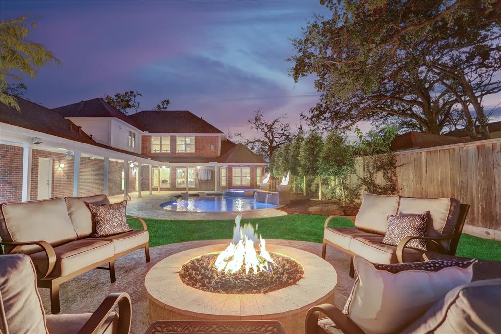 a patio with a table and chairs and a fire pit