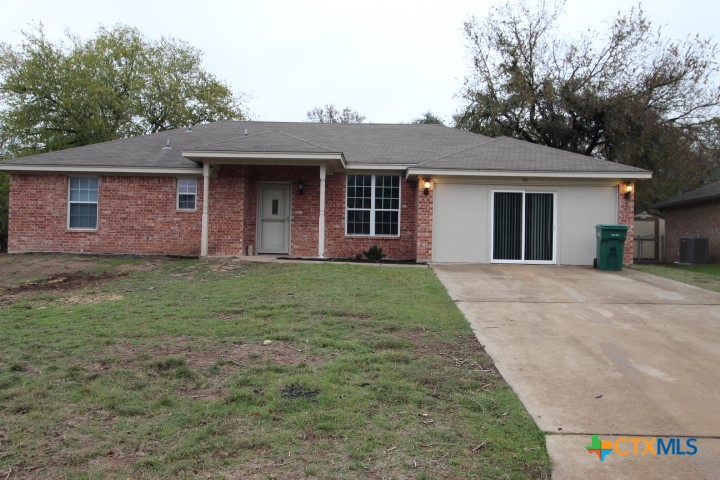 a front view of a house with a yard and trees