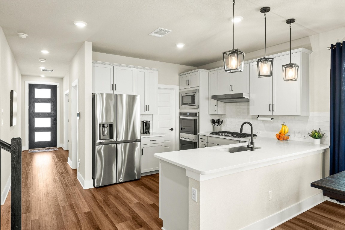 a kitchen that has a lot of cabinets and refrigerator