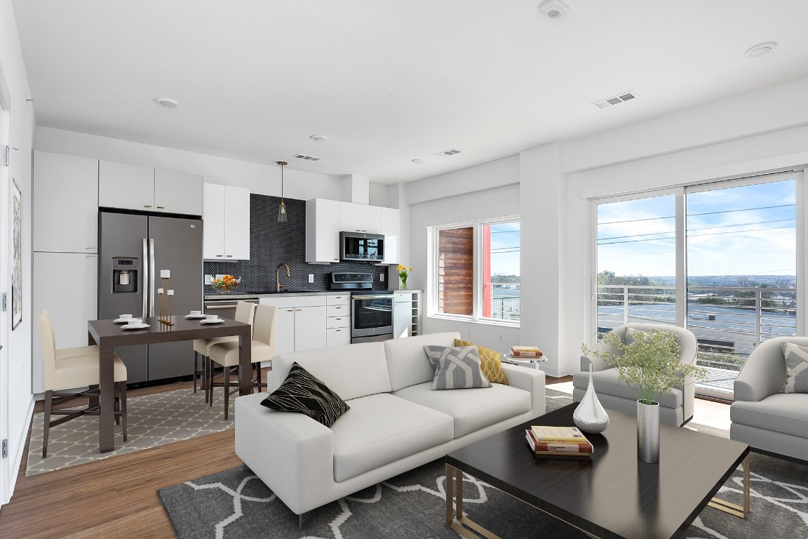 a living room with furniture kitchen view and a large window