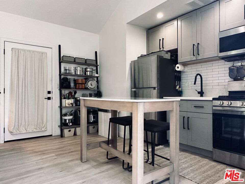 a kitchen with stainless steel appliances granite countertop a refrigerator and a stove top oven