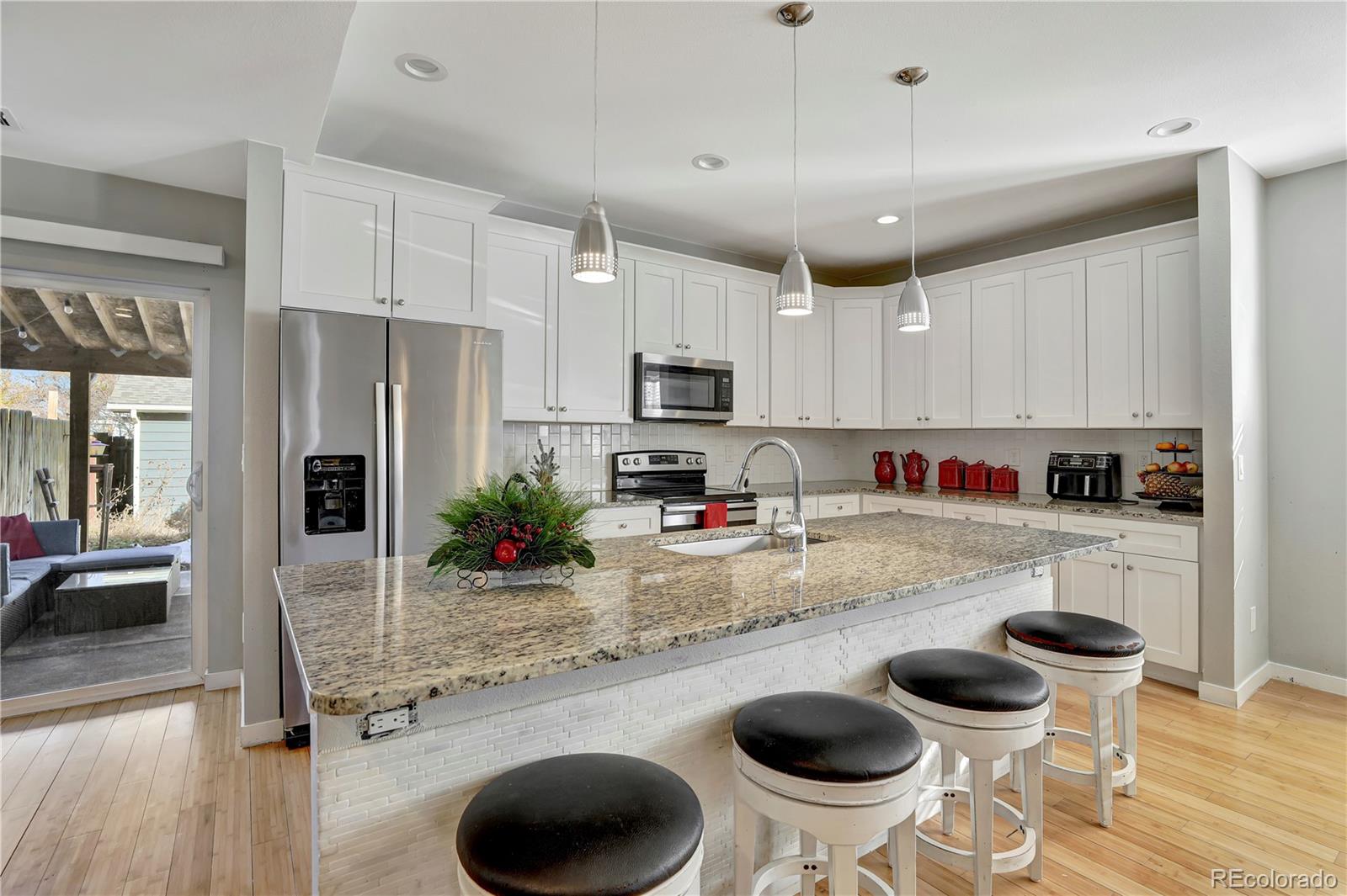 a kitchen with a sink a stove and chairs