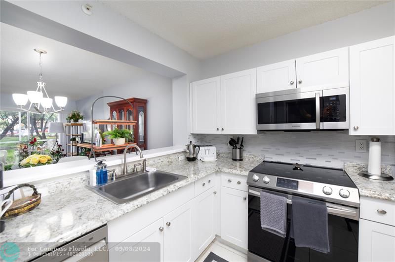 a kitchen with a sink a stove and cabinets