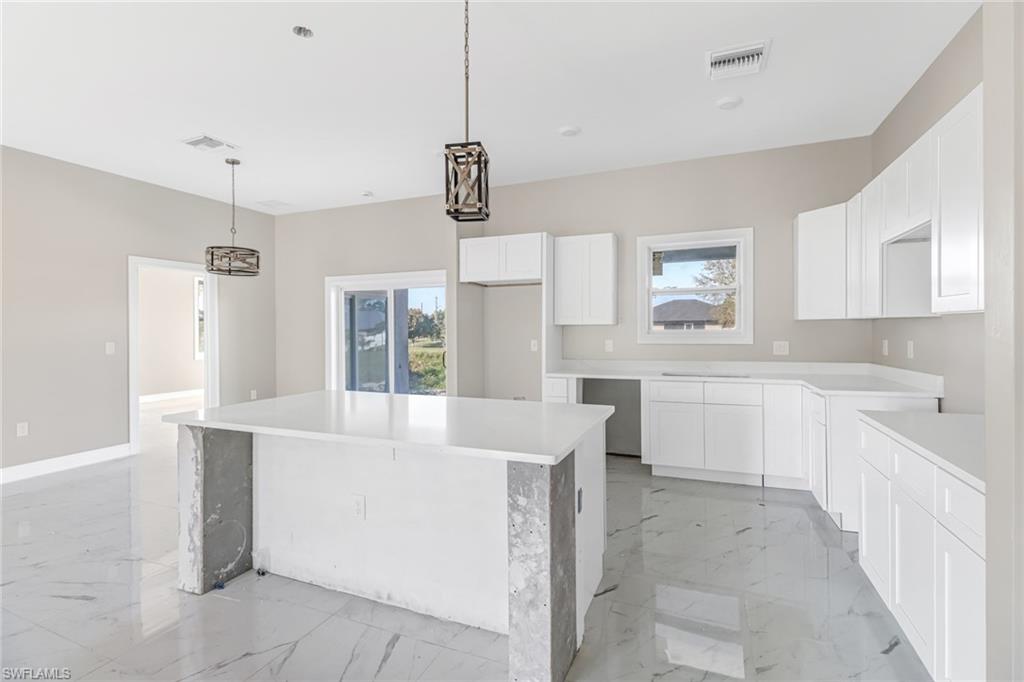 a large white kitchen with cabinets