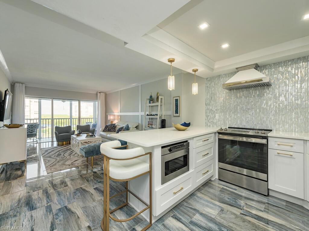 a kitchen with a stove and a view of living room