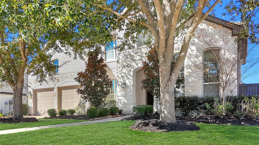 a front view of a house with a yard and tree