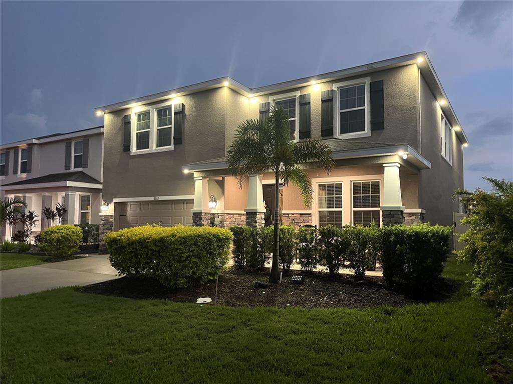 a front view of a house with a yard and plants