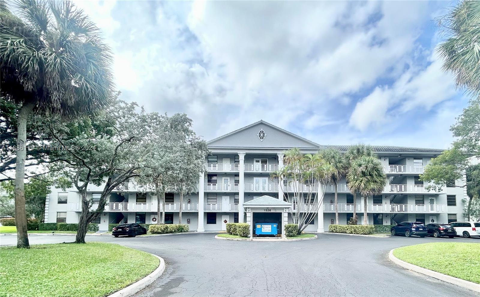 a view of building with lot of cars parked in front of house