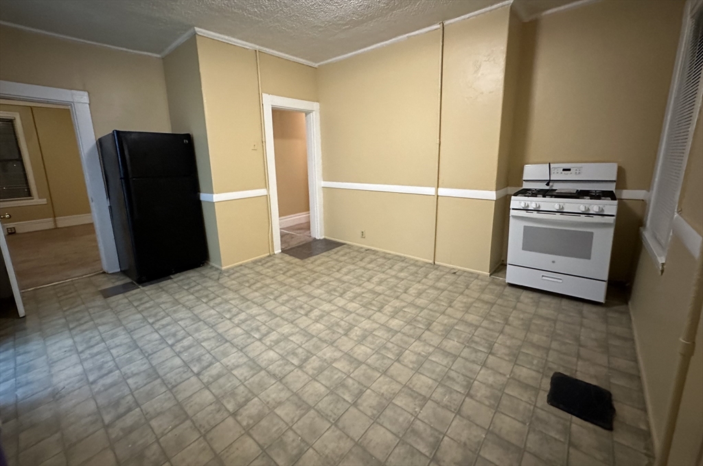 a view of kitchen with refrigerator stove and window