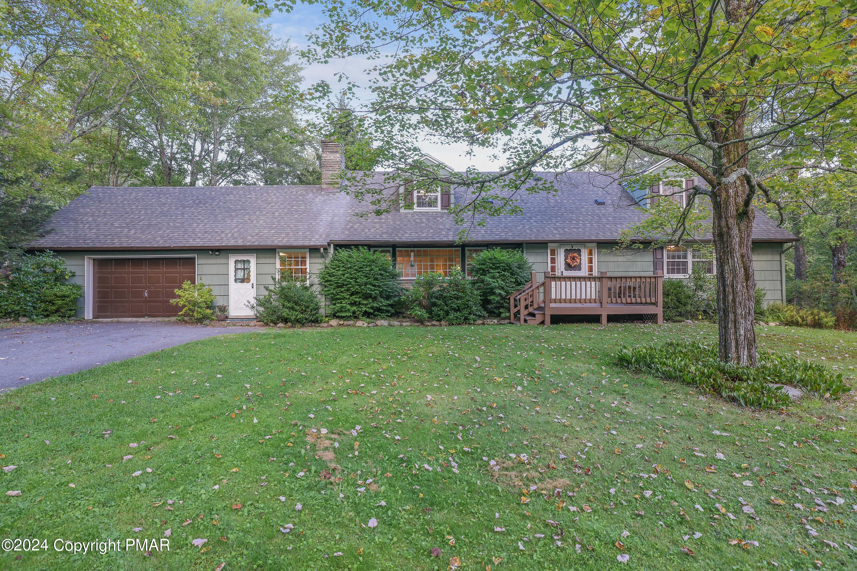 a view of a house with a yard and a large tree