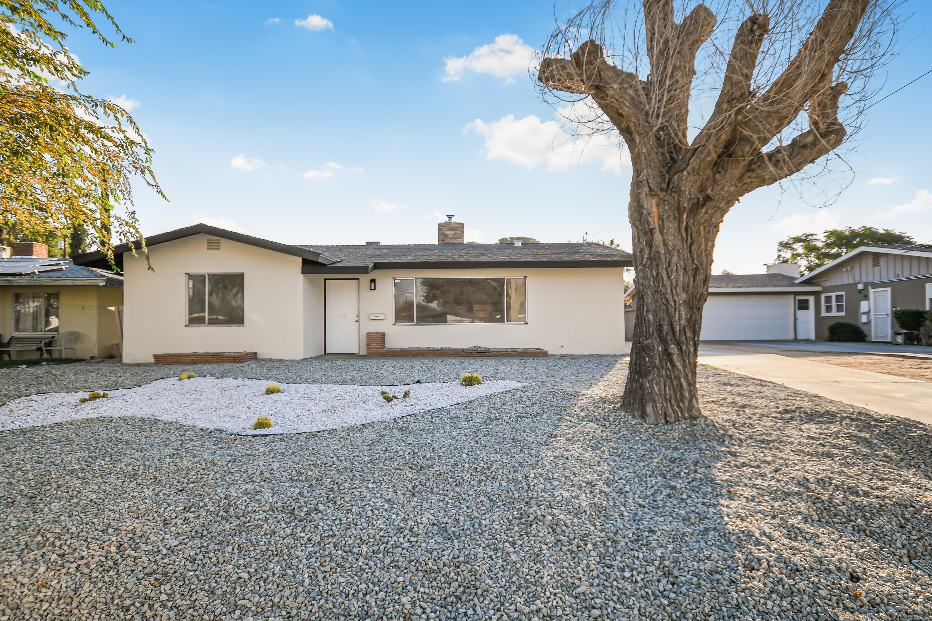 a view of a house with a backyard and a tree