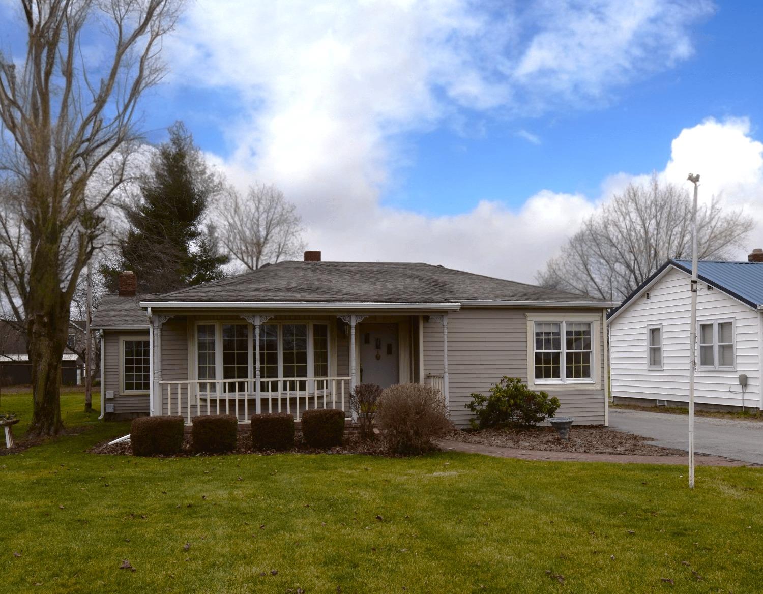 a view of a house with a yard and a large tree