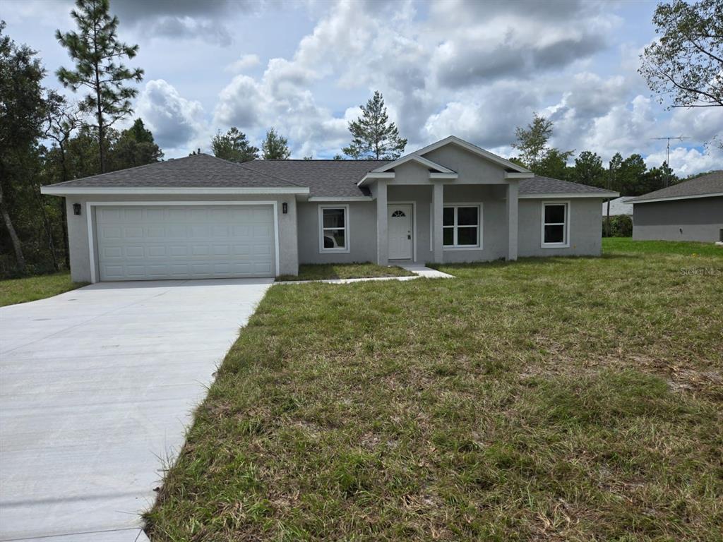 a front view of a house with yard and trees