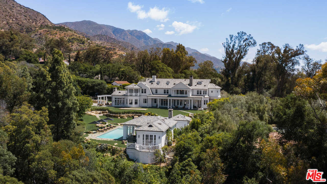 aerial view of a house with a big yard and large trees