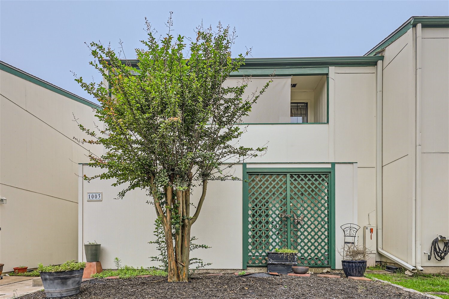 a front view of a house with a tree