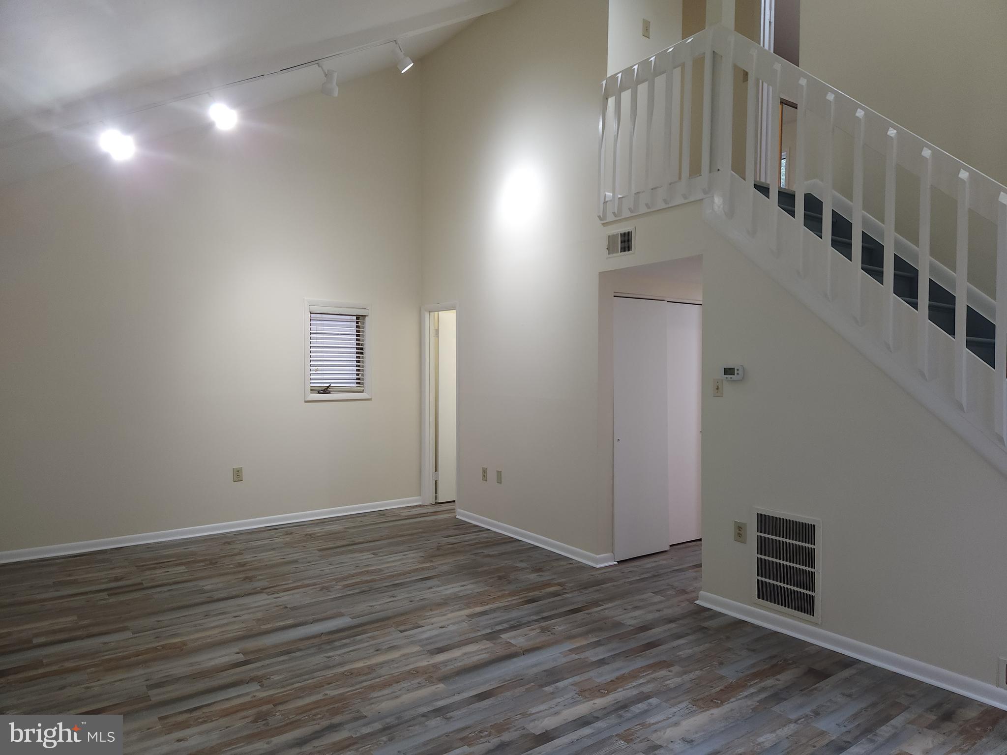 a view of room with stairs and wooden floor