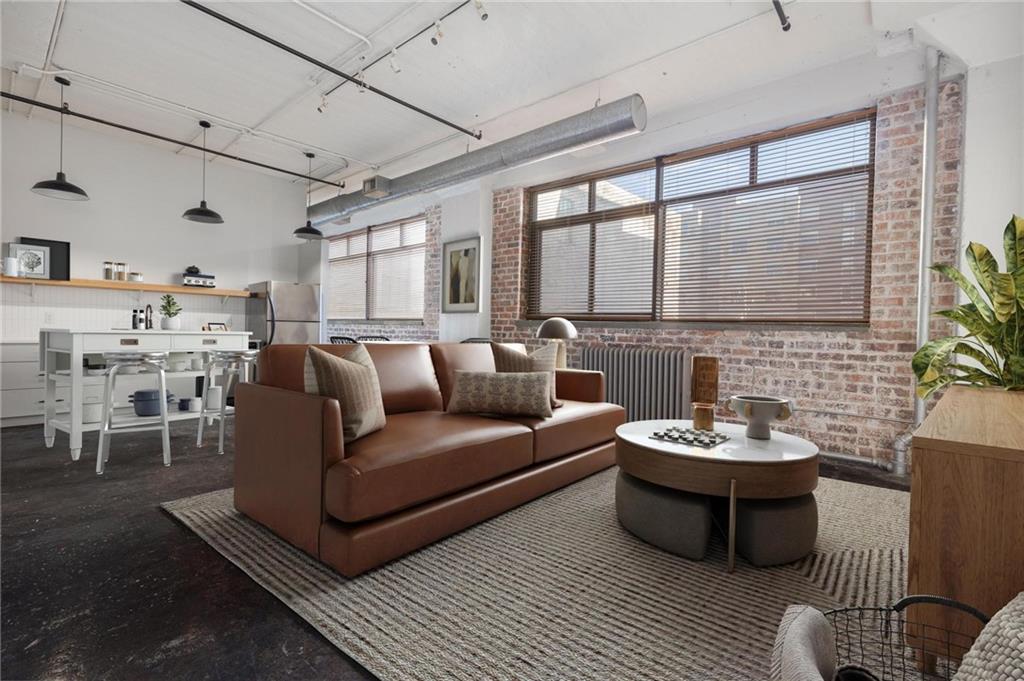 a living room with furniture kitchen view and a large window