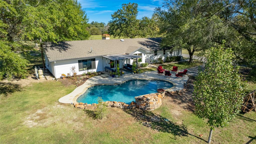 a view of a house with swimming pool and sitting area