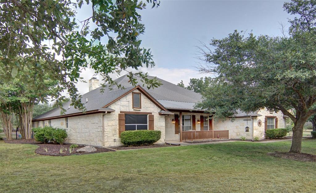 a front view of a house with a garden and trees