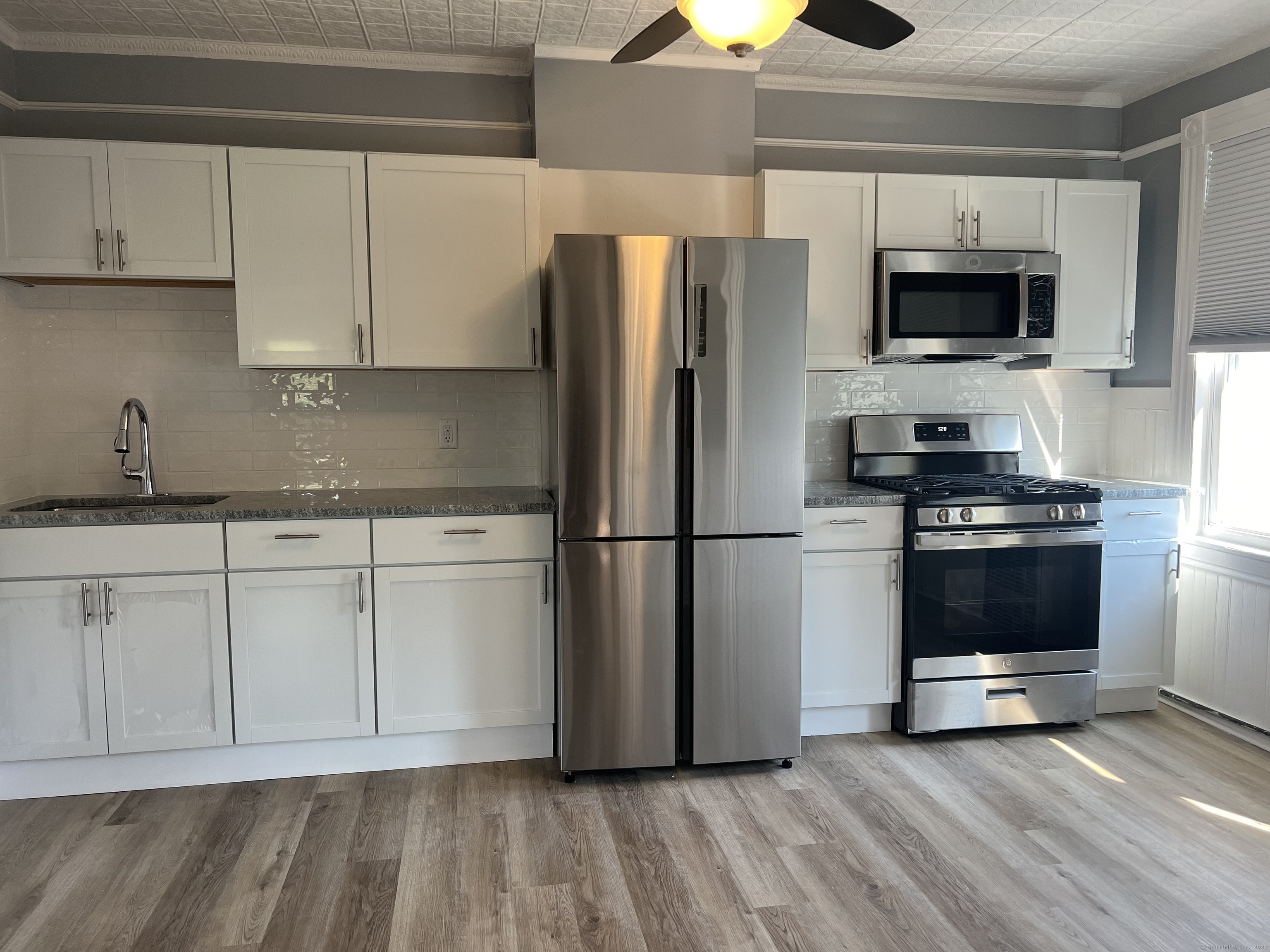 a kitchen with stainless steel appliances a refrigerator stove and microwave