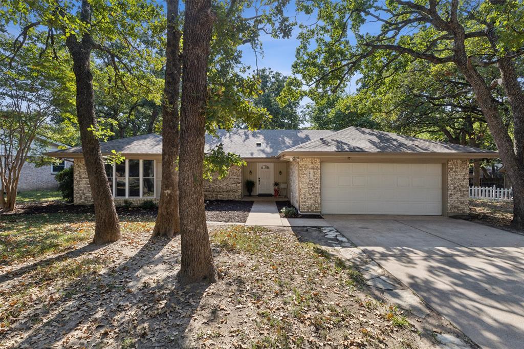 a view of a house with a yard and large tree