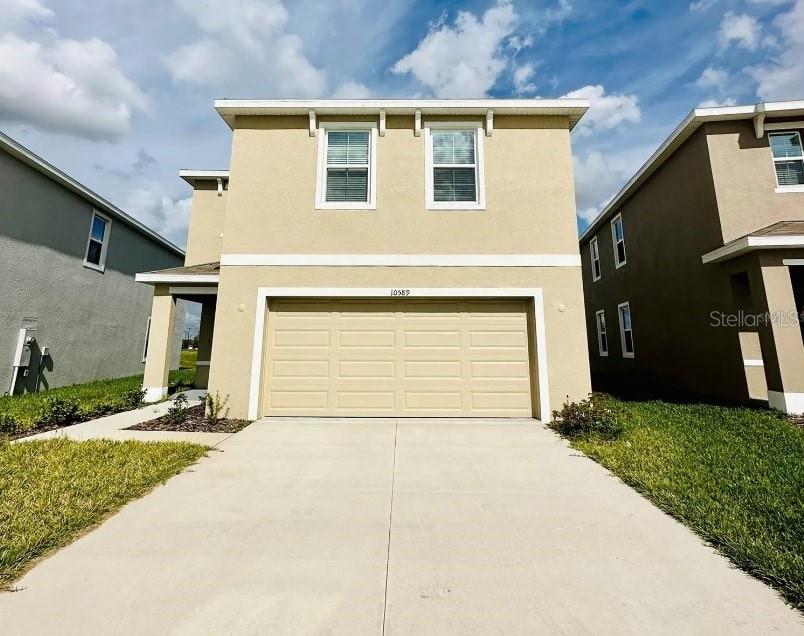 a front view of a house with a yard and garage