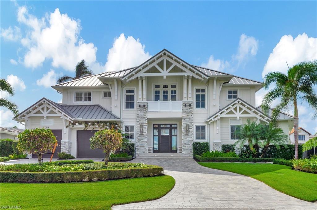 View of front facade with a front lawn, a garage, and a balcony