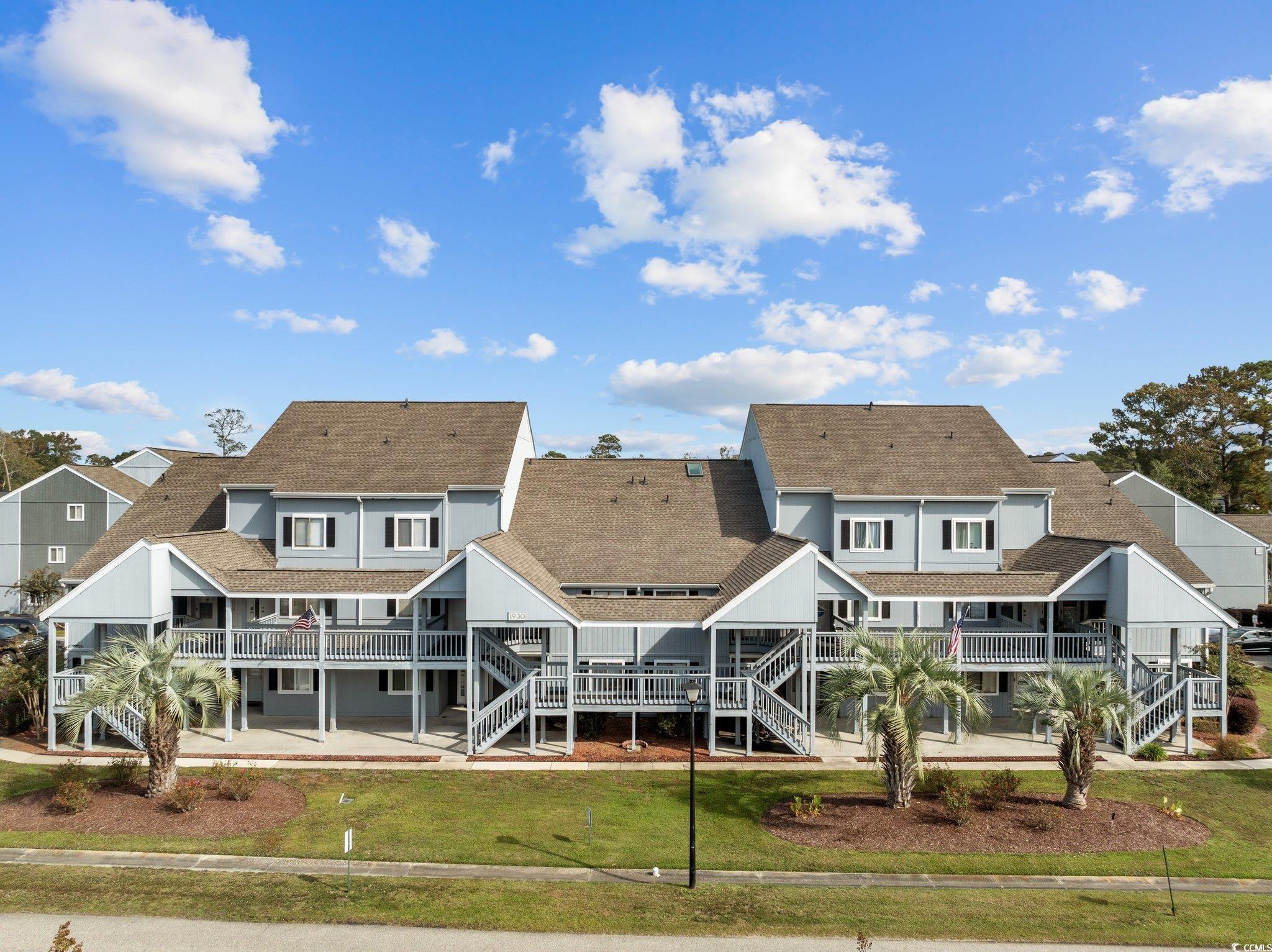 Back of house with a wooden deck and a lawn