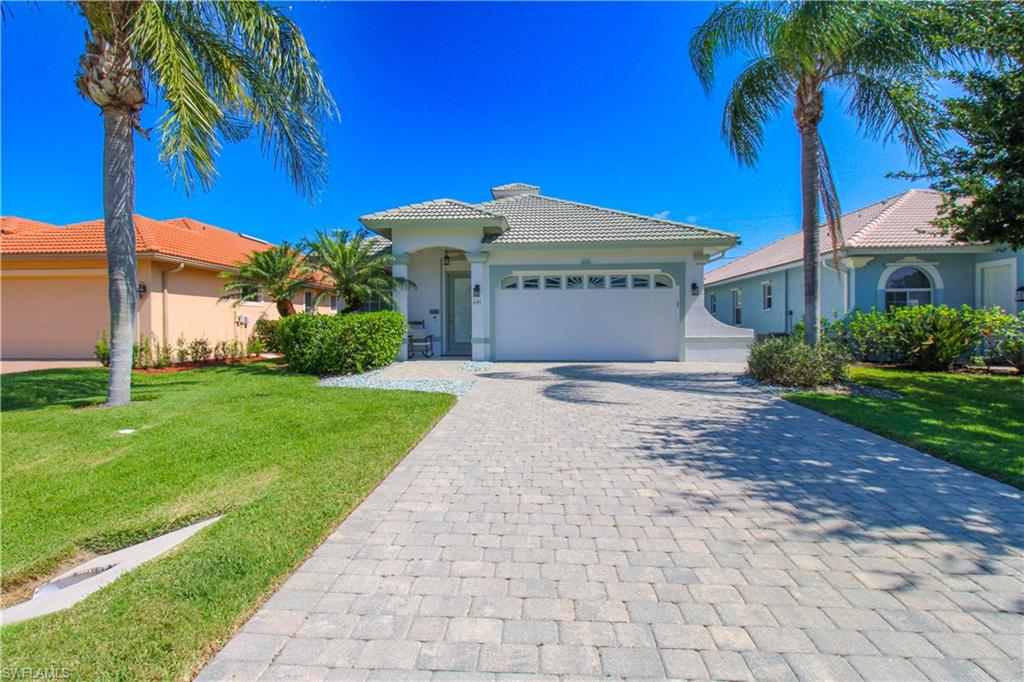 a view of a house with a yard and palm trees