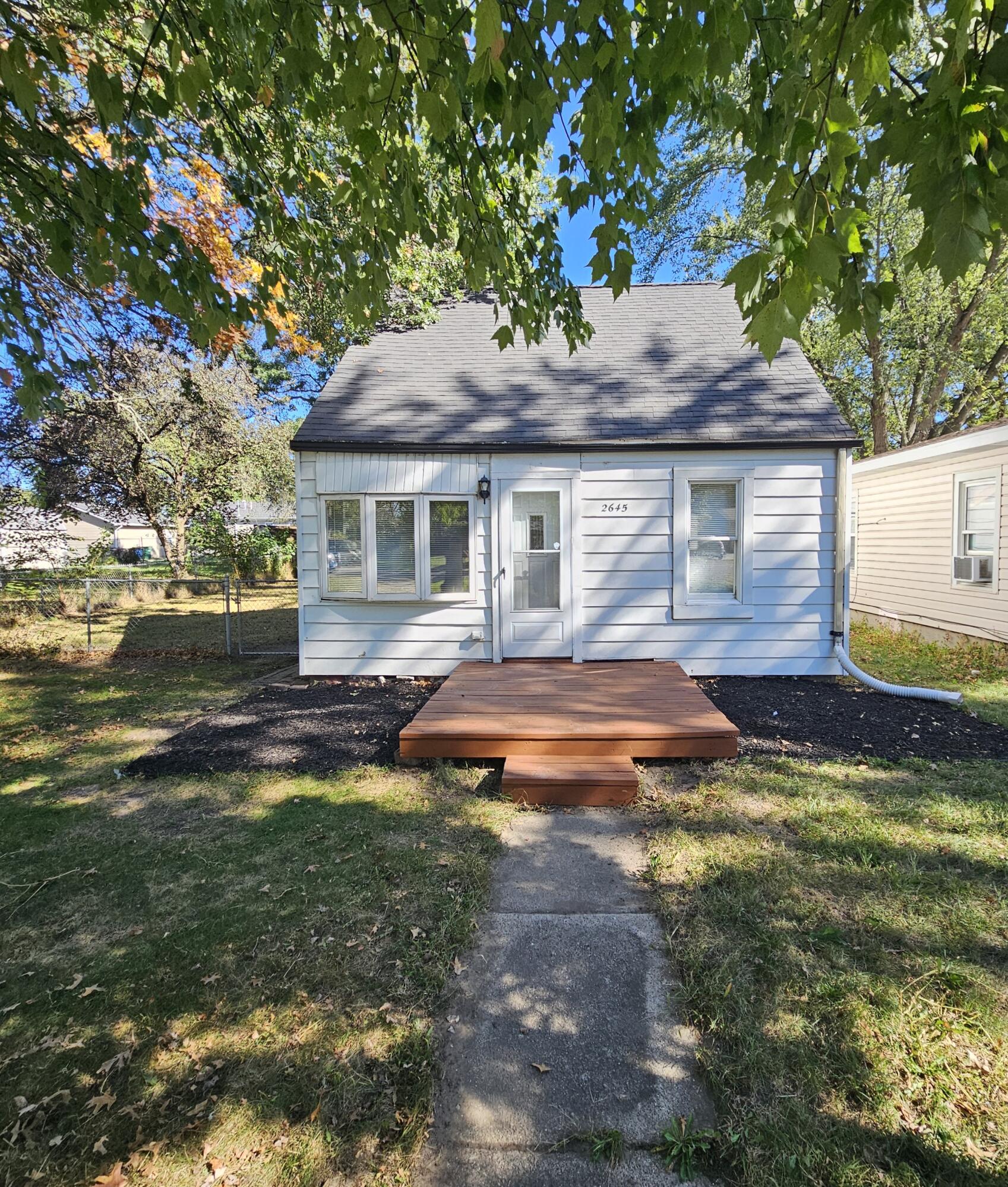 a backyard of a house with yard table and chairs