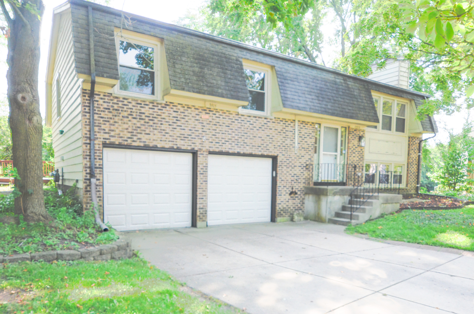 a front view of a house with a garden and garage