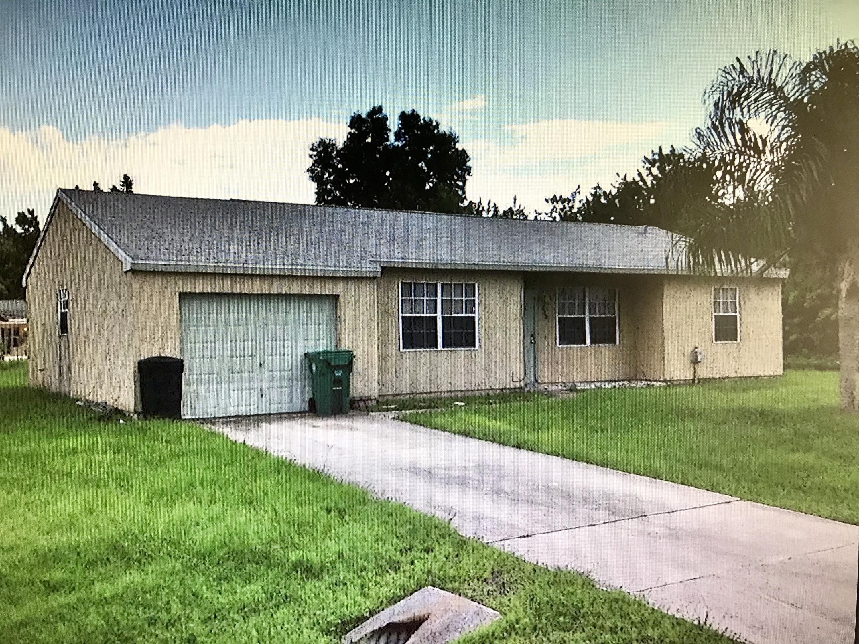 a front view of a house with a garden and yard