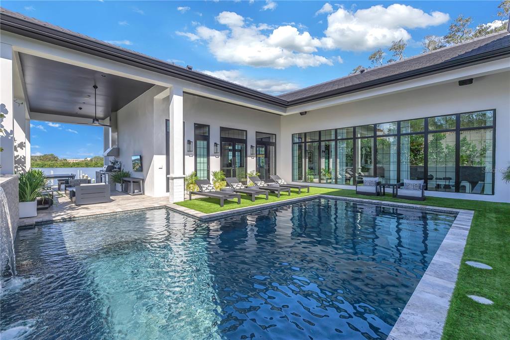 a swimming pool with outdoor seating and yard