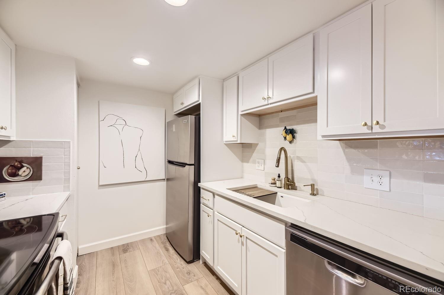 a kitchen with stainless steel appliances granite countertop a refrigerator and a sink