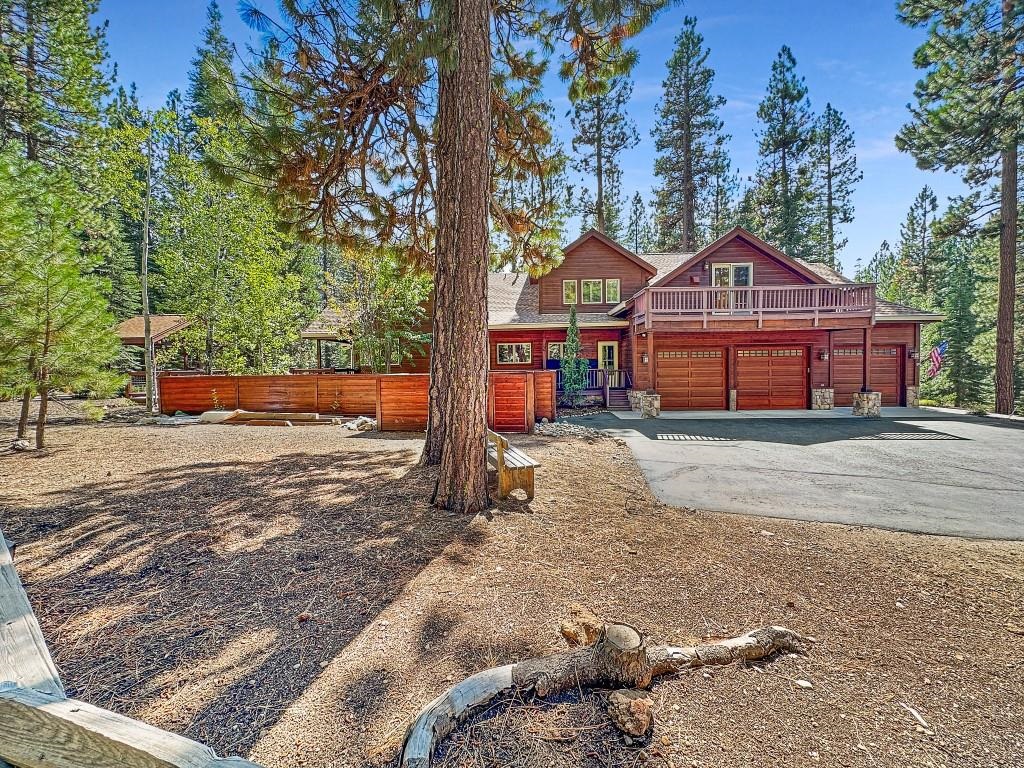 a front view of a house with a yard covered with snow and trees