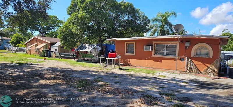 a view of a house with backyard and a tree