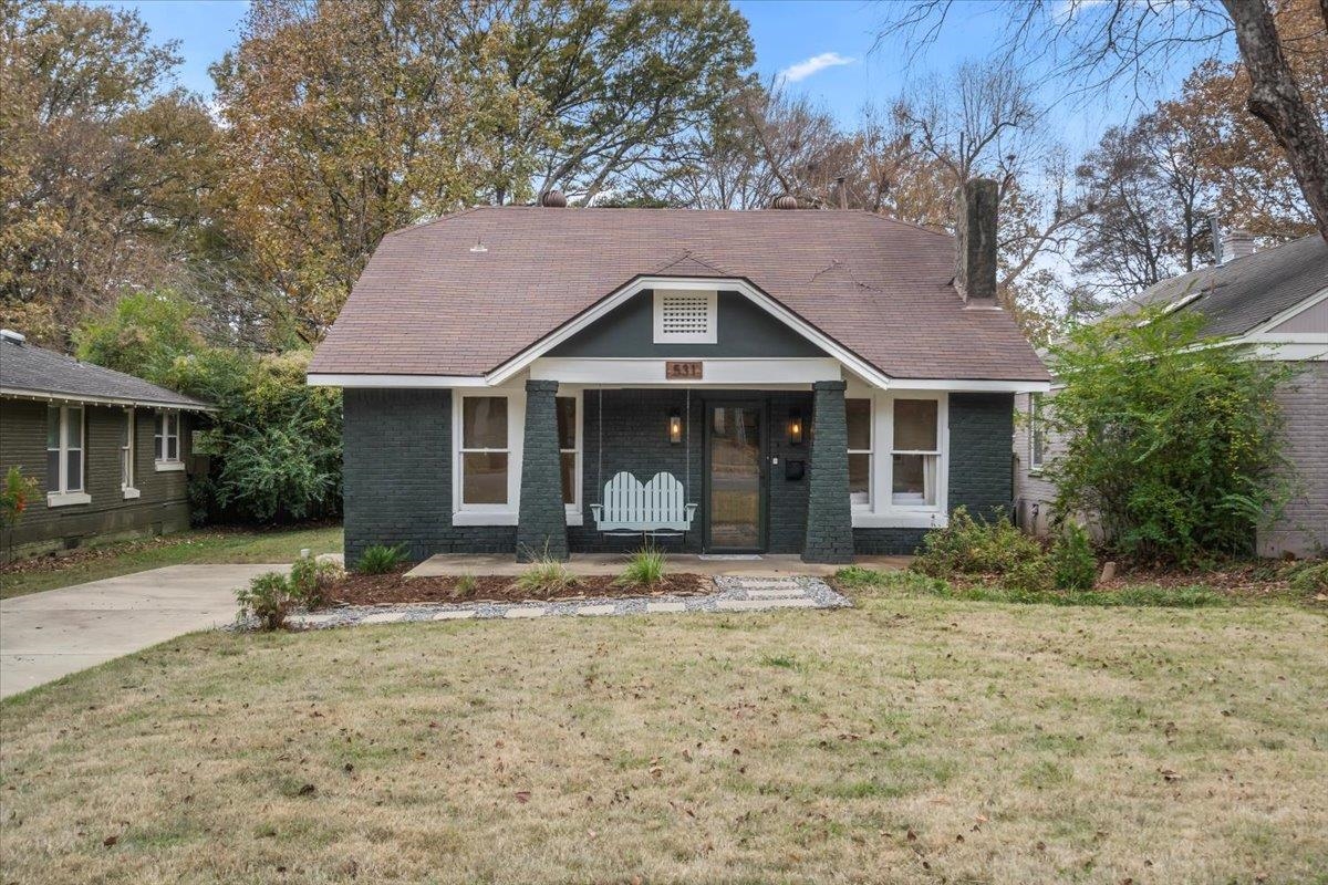 View of front facade with covered porch and a front lawn