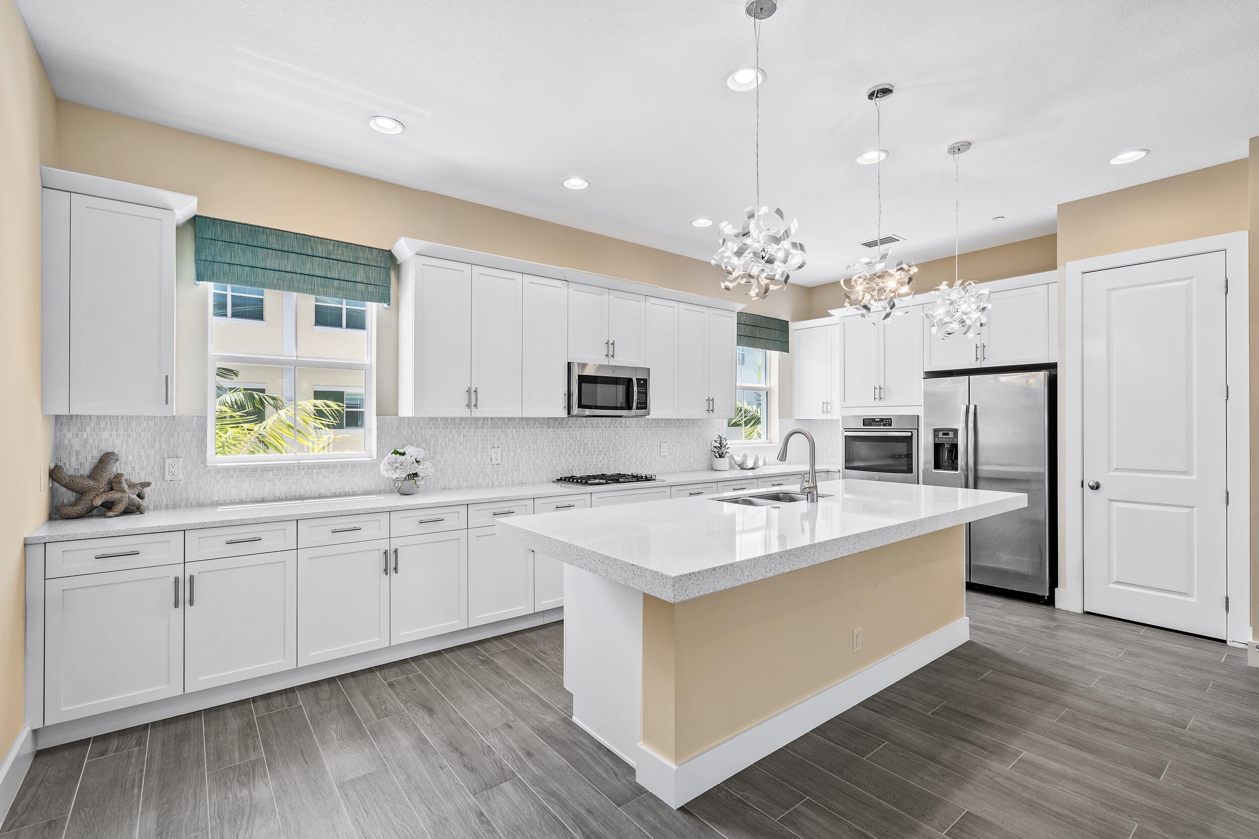 a large white kitchen with a sink stove and refrigerator