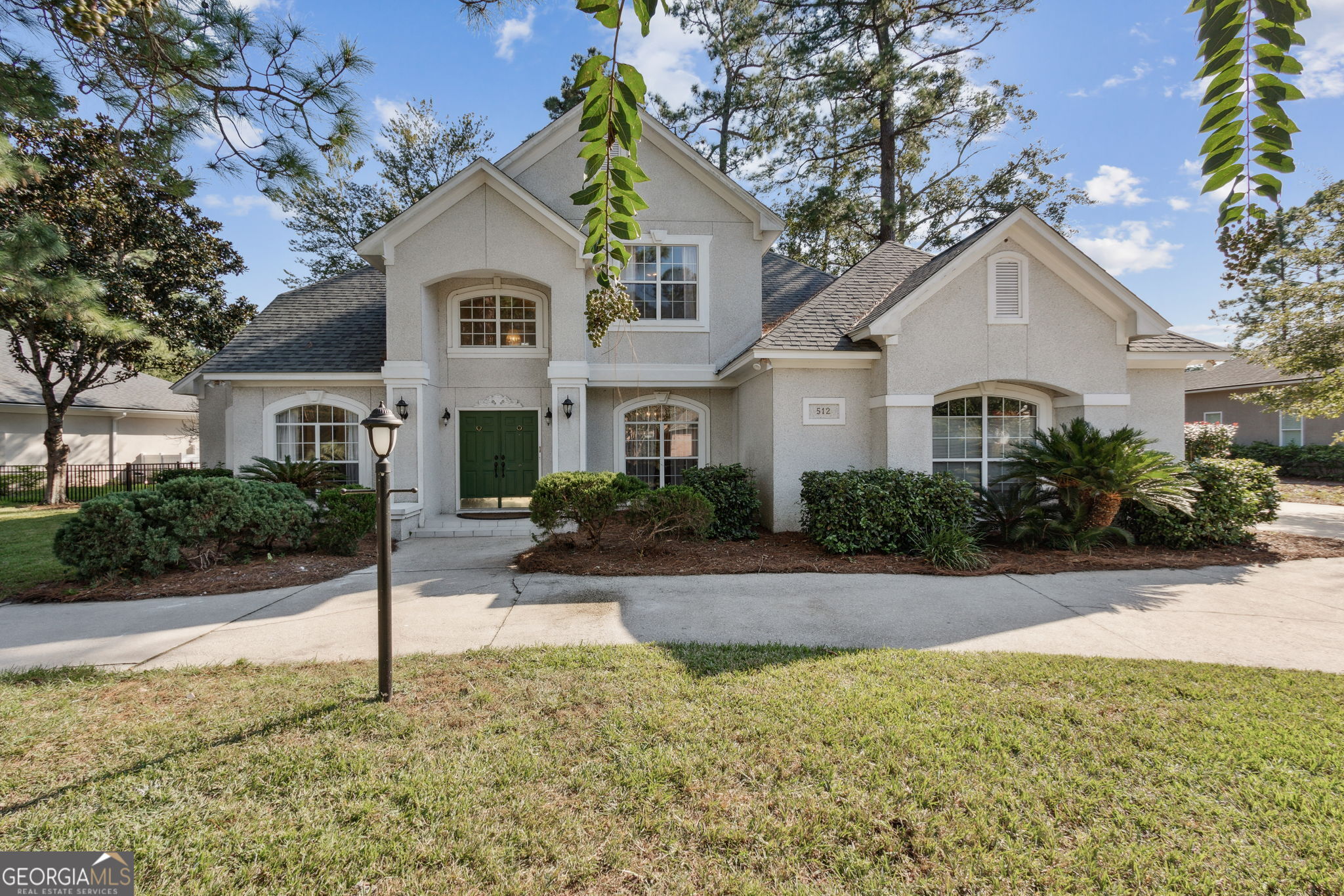 a front view of a house with yard and green space