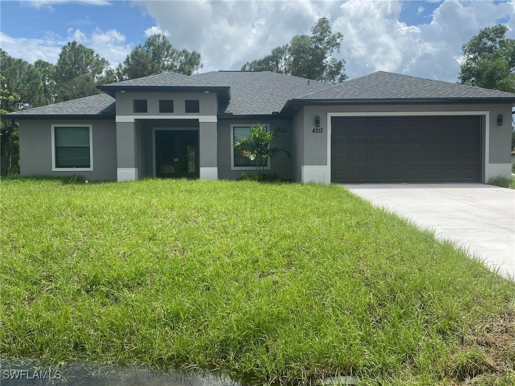 front view of a house with a yard and garage