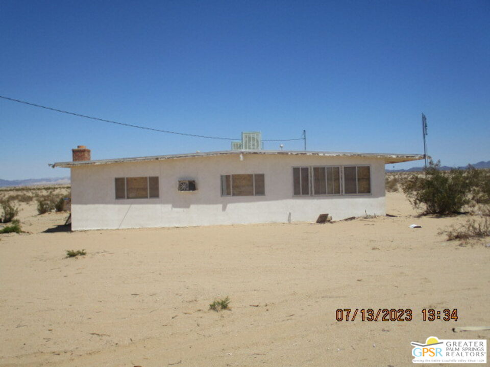 a front view of a house with a snow in the background