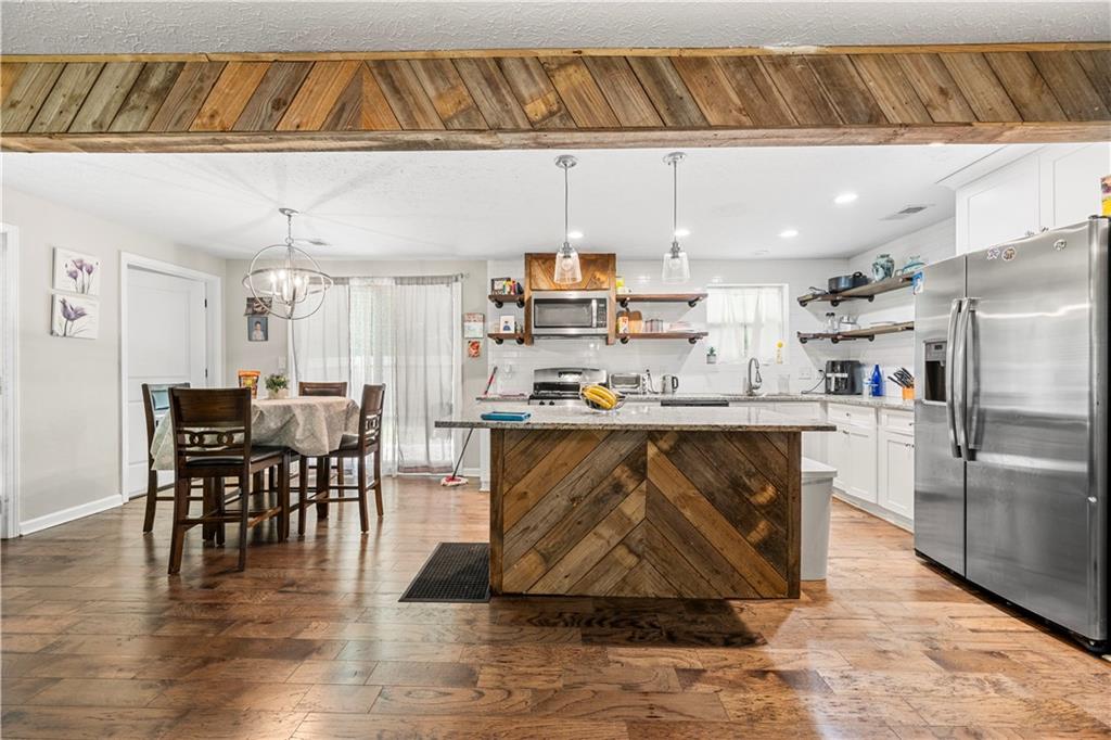 a kitchen with stainless steel appliances granite countertop a refrigerator a stove a sink and dishwasher