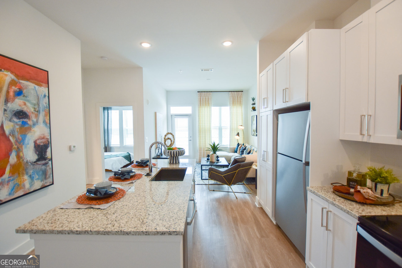 a living room with stainless steel appliances granite countertop furniture and a couch