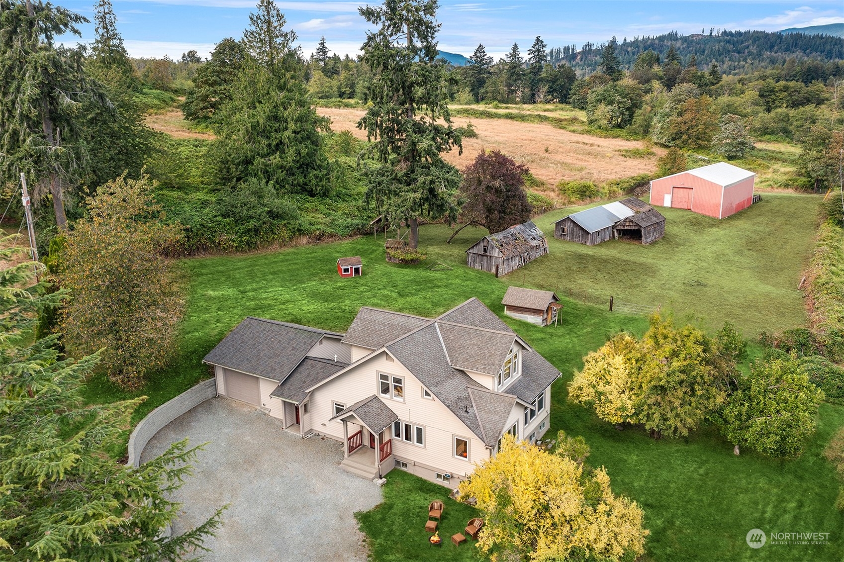 an aerial view of a house with pool big yard and large trees