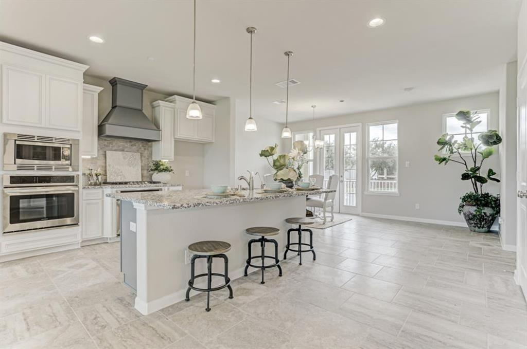 a kitchen with stainless steel appliances kitchen island granite countertop a stove a sink and a refrigerator